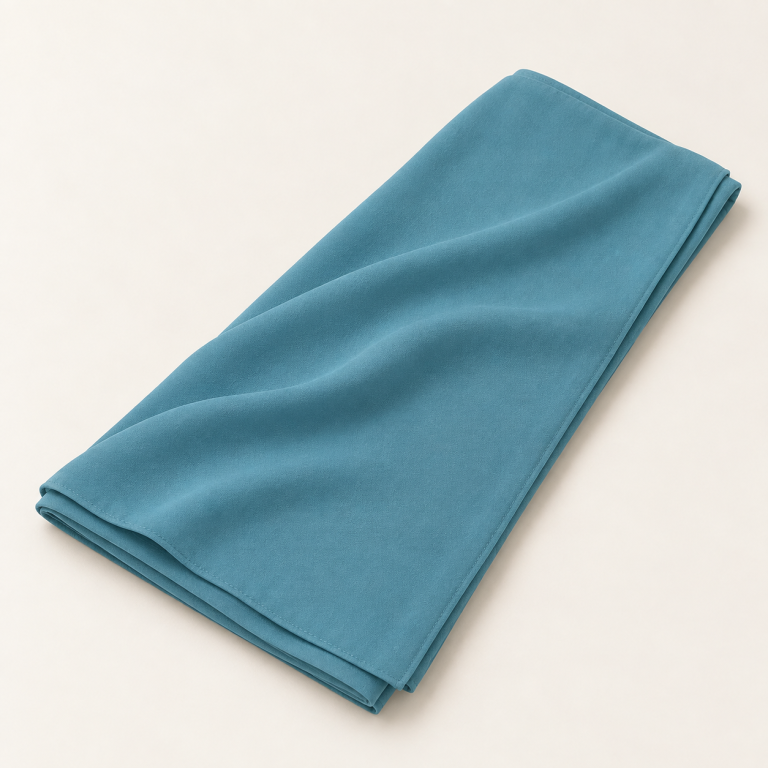 Voile soie de Médine bleu lagon, plié avec un drapé sur fond clair