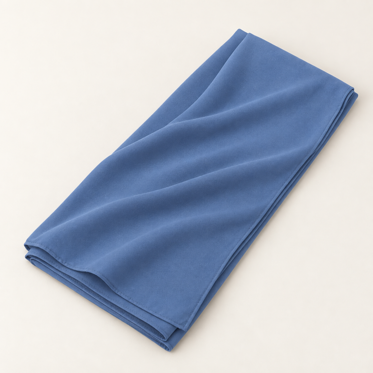 Voile soie de Médine bleu denim, plié avec un drapé sur fond clair